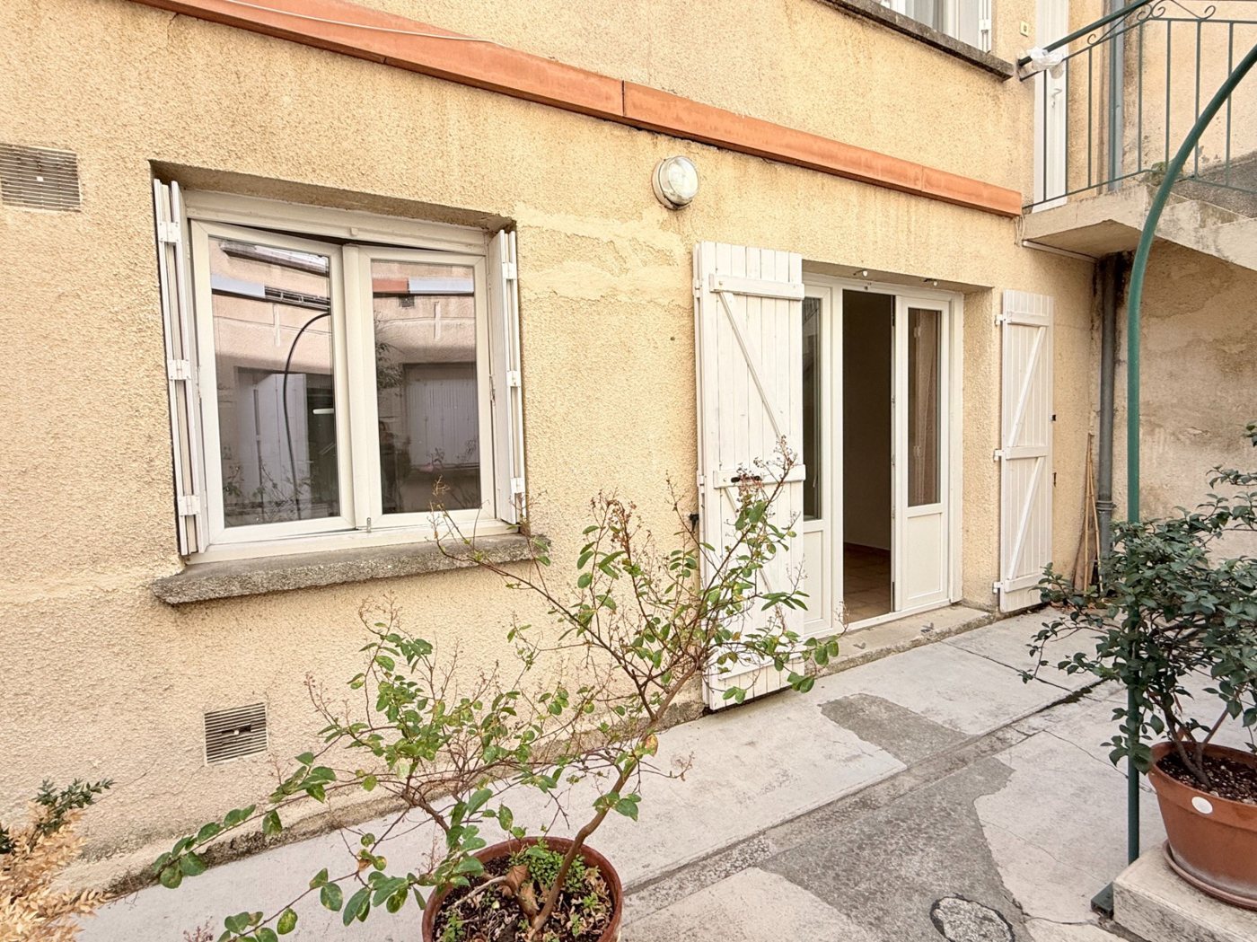 L'entrée du studio, volets blancs sur la cour